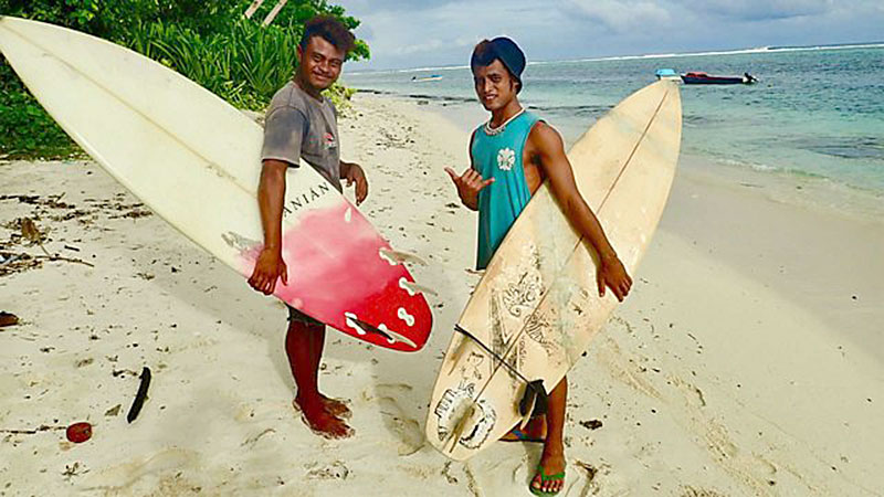 Two young men on a beach with surf boards